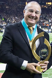 Paul Varisco, Peoples Health Champion, at a Saints game holding his Champions Medal