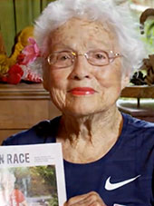 Julia Hawkins, Peoples Health Champion, holding the magazine article featuring her accomplishments.